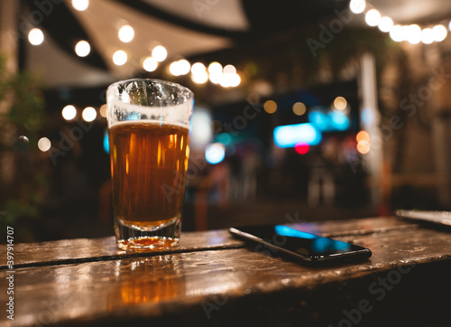 beer and mobile phone on table in bar