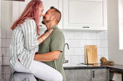 couple kissing in the kitchen with loft light interior, romantic time, weekends, in domestic clothes