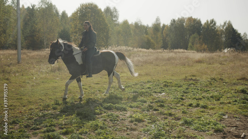 A young rider sets off early in the morning on a long horse ride through rough terrain and woods. © iaginzburg