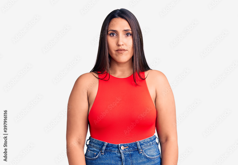 Obraz premium Young beautiful brunette woman wearing casual sleevelss t-shirt with serious expression on face. simple and natural looking at the camera.