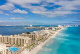Espectacular vista aérea de la zona hotelera de Cancún, en Quintana Roo, México con un cielo azul y nublado como fondo.