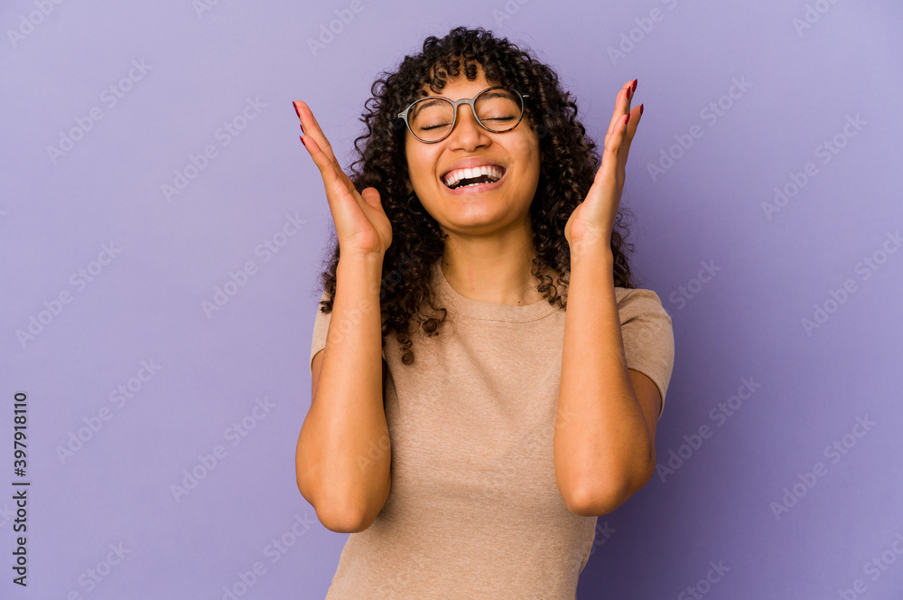 Young african american afro woman isolated laughs out loudly keeping hand on chest. Young african american afro woman isolated laughs out loudly keeping hand on chest.