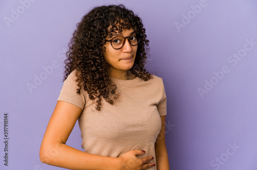 Young african american afro woman isolated touches tummy, smiles gently, eating and satisfaction concept.