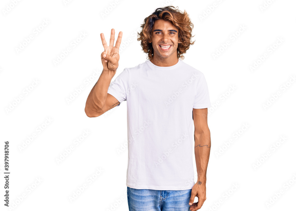 Young hispanic man wearing casual white tshirt showing and pointing up with fingers number three while smiling confident and happy. Young hispanic man wearing casual white tshirt showing and pointing up with fingers number three while smiling confident and happy.