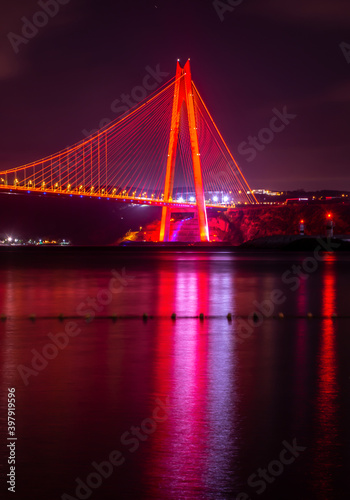Fototapeta Naklejka Na Ścianę i Meble -  Panoramic view of the Yavuz Sultan Selim Bridge with backlit in Istanbul, Turkey. Night time. Third Istanbul bridge.
