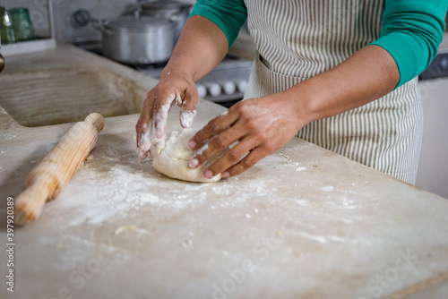 woman in a traditional vintage kitchen making a dough to make a homemade bread