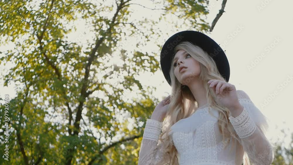 Young cute girl in a white dress posing beautifully in sun flares. Positive attitude. Slow motion Young cute girl in a white dress posing beautifully in sun flares. Positive attitude. Slow motion
