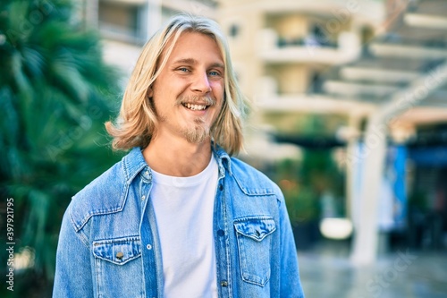 Young blond scandinavian man smiling happy standing at the city.
