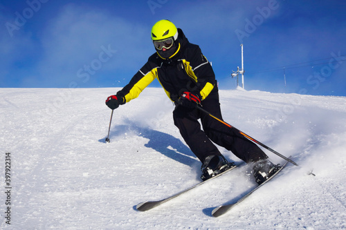 Skier skiing downhill in mountains photo