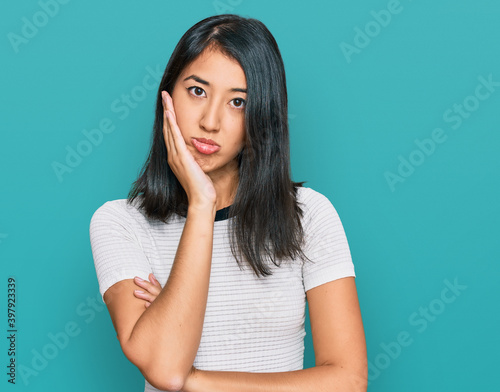 Beautiful asian young woman wearing casual white t shirt thinking looking tired and bored with depression problems with crossed arms.