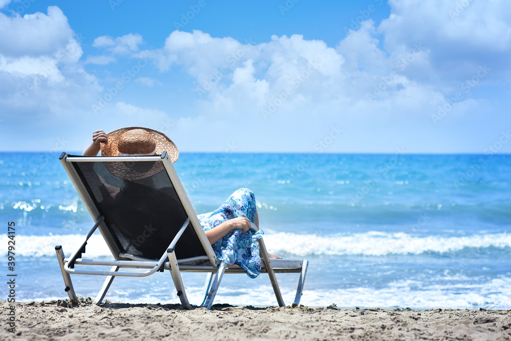 Happy young traveller woman with hat enjoys her beach vacation. Relaxing joyful in summer near sea on a beach. Outdoors lifestyle. Summer vacation and freedom concept. Meditation. Happy young traveller woman with hat enjoys her beach vacation. Relaxing joyful in summer near sea on a beach. Outdoors lifestyle. Summer vacation and freedom concept. Meditation.
