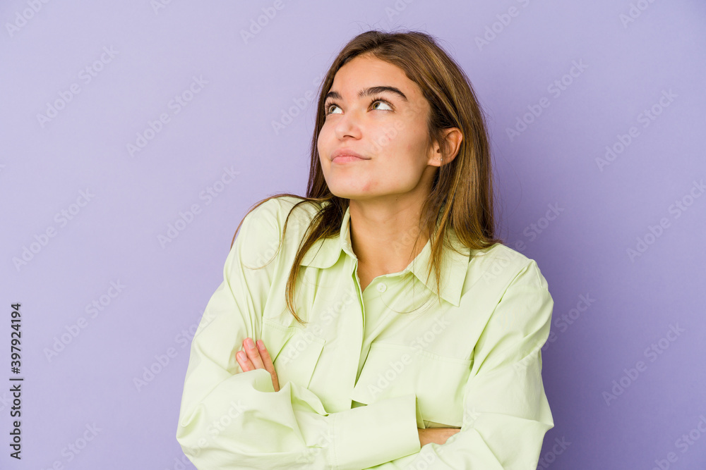 Young skinny caucasian girl teenager on purple background dreaming of achieving goals and purposes Young skinny caucasian girl teenager on purple background dreaming of achieving goals and purposes