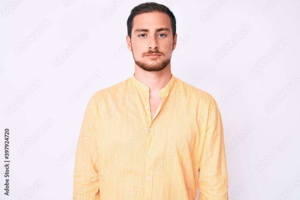 Young handsome man wearing casual clothes with serious expression on face. simple and natural looking at the camera. Young handsome man wearing casual clothes with serious expression on face. simple and natural looking at the camera.