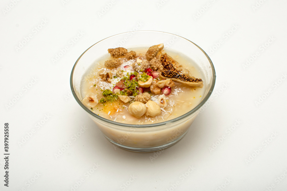 Closeup of traditional Turkish Dessert Asure or Ashura (aka Noah Pudding) in glass bowls isolated on white background. with copy space for text. Closeup of traditional Turkish Dessert Asure or Ashura (aka Noah Pudding) in glass bowls isolated on white background. with copy space for text.