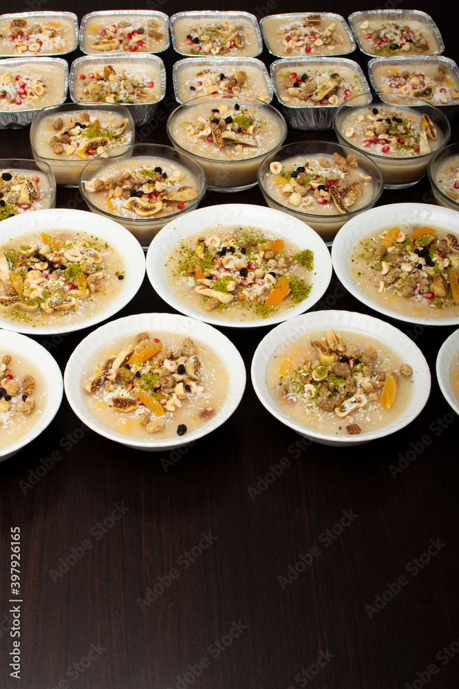 Closeup of traditional Turkish Dessert Asure or Ashura (aka Noah Pudding) in white bowls isolated on black backgroun