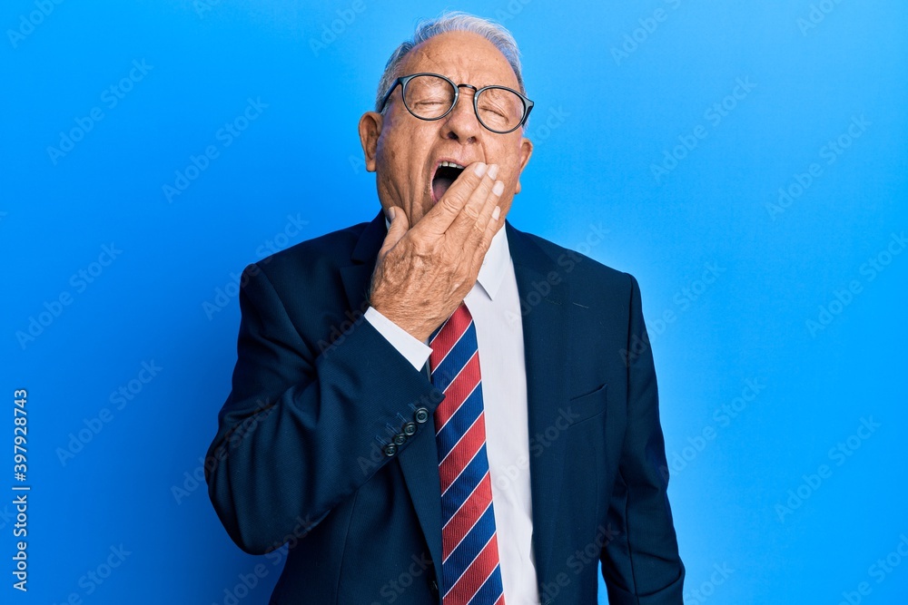 Senior caucasian man wearing business suit and tie bored yawning tired covering mouth with hand. restless and sleepiness. Senior caucasian man wearing business suit and tie bored yawning tired covering mouth with hand. restless and sleepiness.