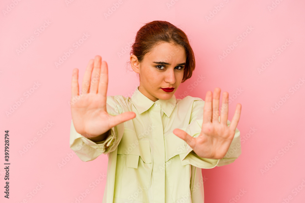 Young arab mixed race woman standing with outstretched hand showing stop sign, preventing you. Young arab mixed race woman standing with outstretched hand showing stop sign, preventing you.