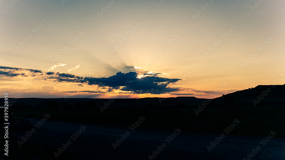 Panorama shot of colorful sunset behind clouds in Badland national park in america