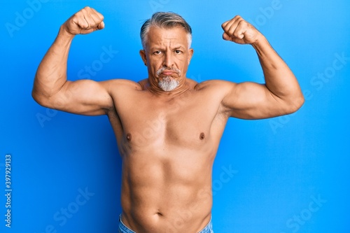 Middle age grey-haired man standing shirtless doing fitness gesture depressed and worry for distress, crying angry and afraid. sad expression.