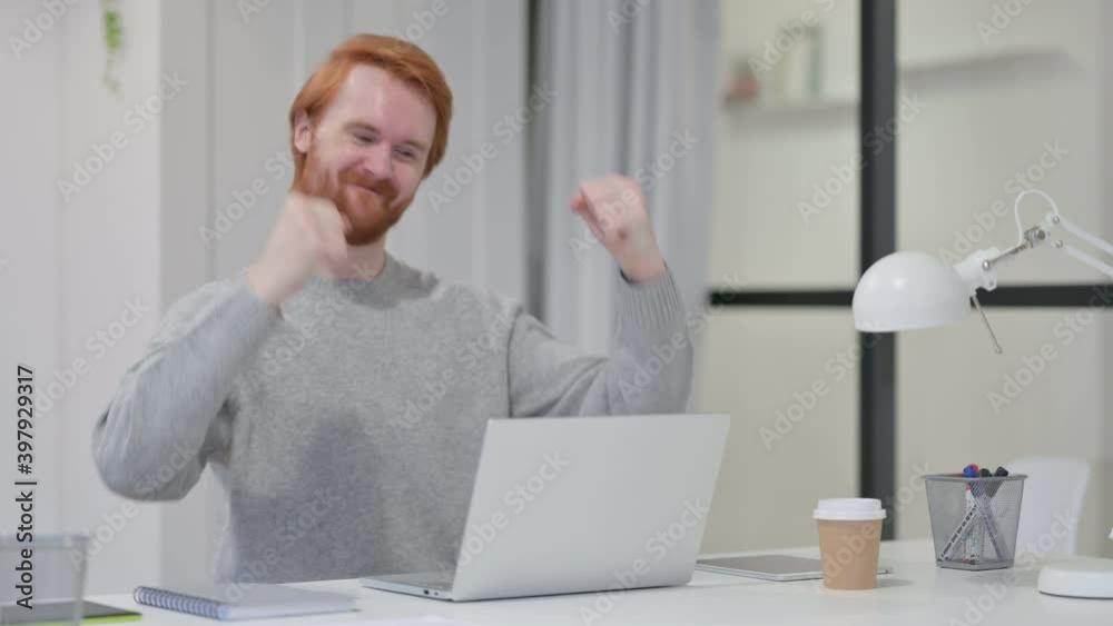 Successful Redhead Man Celebrating on Laptop at Work Successful Redhead Man Celebrating on Laptop at Work