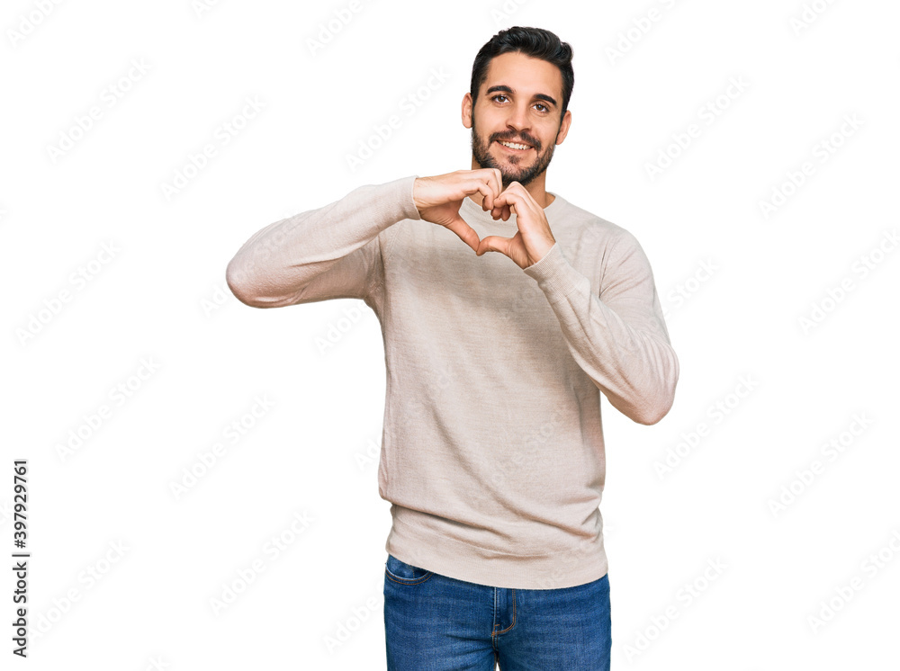 Young hispanic man wearing casual clothes smiling in love doing heart symbol shape with hands. romantic concept. Young hispanic man wearing casual clothes smiling in love doing heart symbol shape with hands. romantic concept.