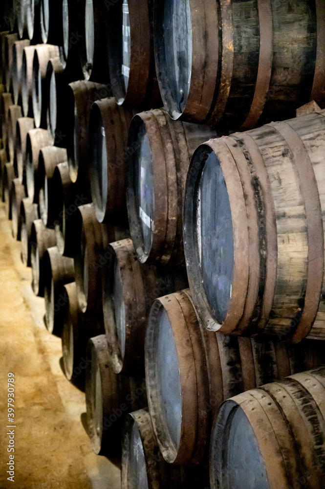 Old porto lodge with rows of oak wooden casks for slow aging of fortified ruby or tawny porto wine in Vila Nova de Gaia, Portugal Old porto lodge with rows of oak wooden casks for slow aging of fortified ruby or tawny porto wine in Vila Nova de Gaia, Portugal