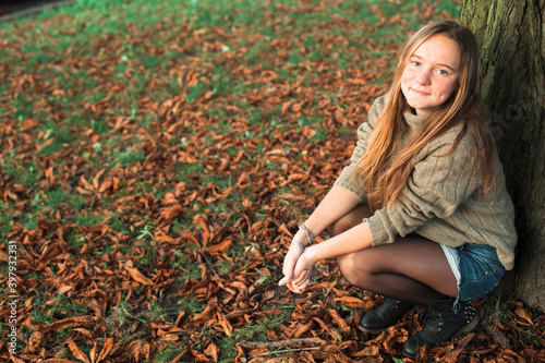 Teen girl posing in autumn park.