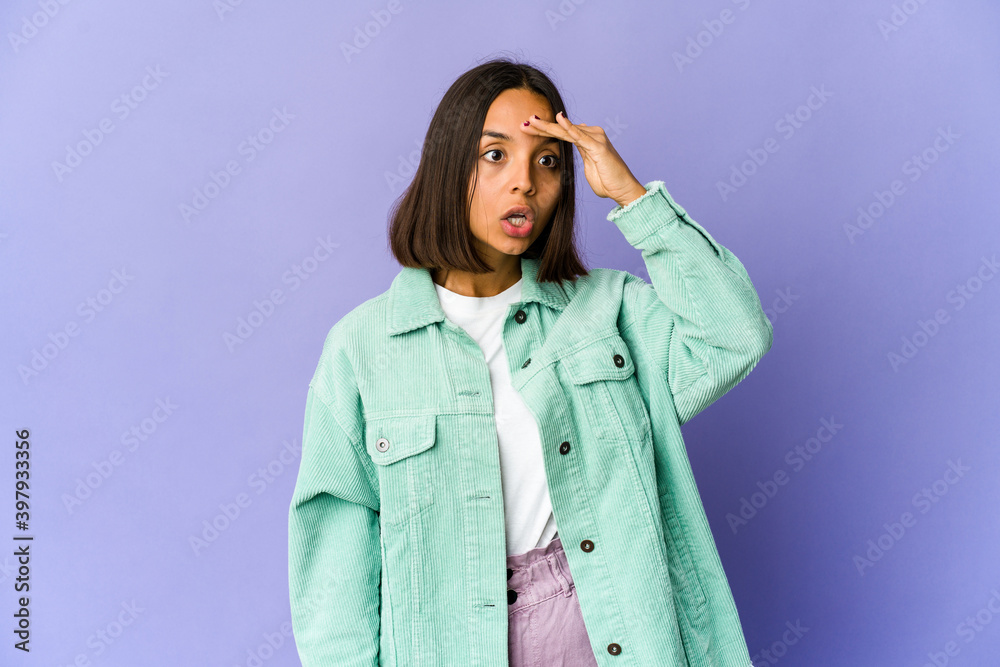 Young mixed race woman looking far away keeping hand on forehead. Young mixed race woman looking far away keeping hand on forehead.