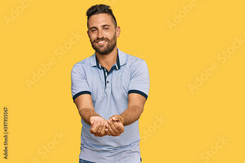 Handsome man with beard wearing casual clothes smiling with hands palms together receiving or giving gesture. hold and protection