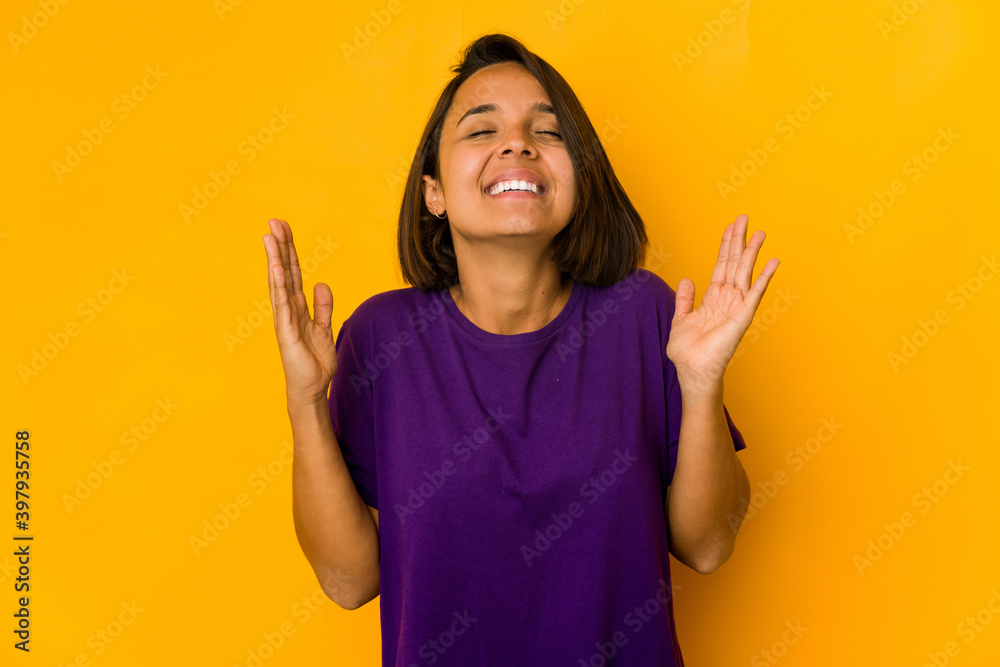 Young hispanic woman isolated on yellow laughs out loudly keeping hand on chest. Young hispanic woman isolated on yellow laughs out loudly keeping hand on chest.