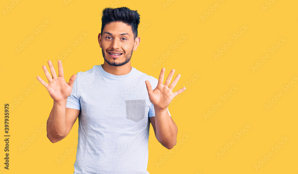 Handsome latin american young man wearing casual clothes showing and pointing up with fingers number ten while smiling confident and happy. Handsome latin american young man wearing casual clothes showing and pointing up with fingers number ten while smiling confident and happy.