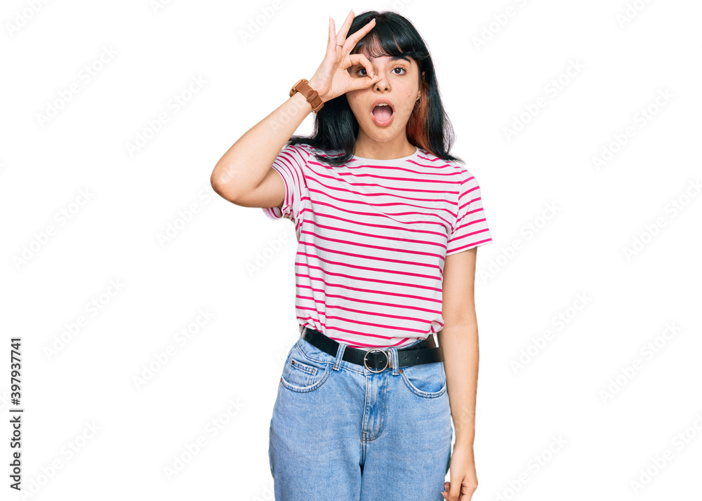Young hispanic girl wearing casual clothes doing ok gesture shocked with surprised face, eye looking through fingers. unbelieving expression. Young hispanic girl wearing casual clothes doing ok gesture shocked with surprised face, eye looking through fingers. unbelieving expression.