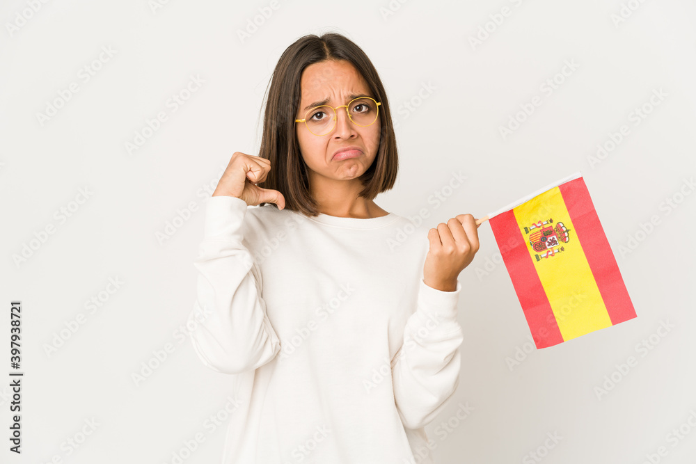 Young hispanic mixed race woman holding a spanish flag feels proud and self confident, example to follow. Young hispanic mixed race woman holding a spanish flag feels proud and self confident, example to follow.