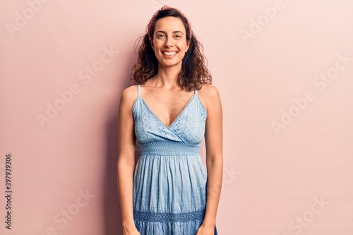 Young beautiful hispanic woman wearing casual dress and diadem with a happy and cool smile on face. lucky person.