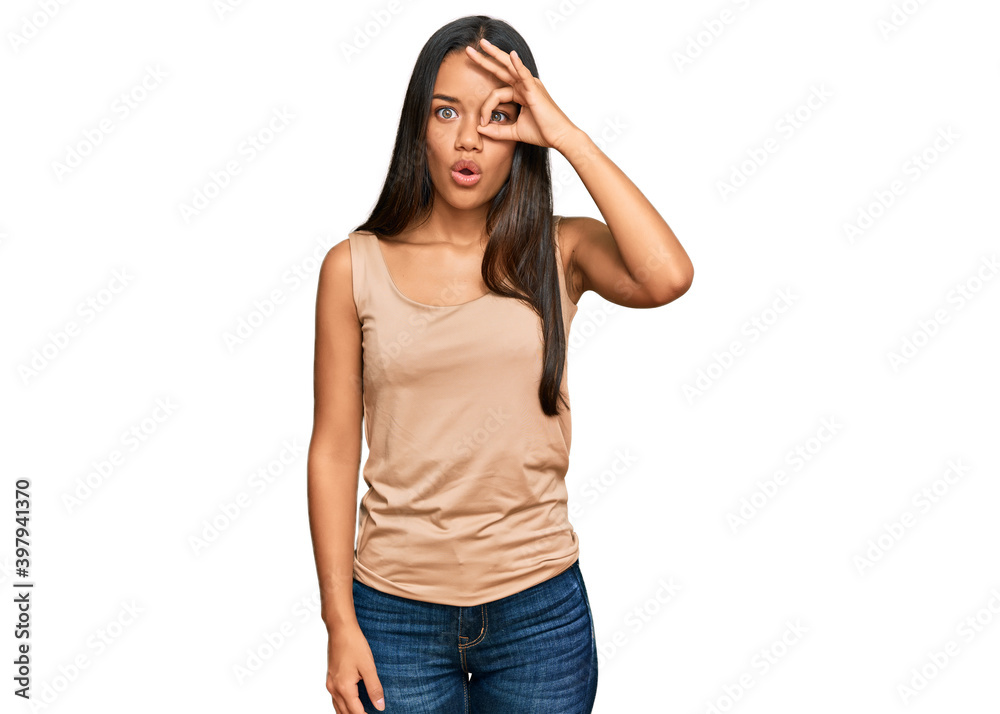 Beautiful hispanic woman wearing casual clothes doing ok gesture shocked with surprised face, eye looking through fingers. unbelieving expression. Beautiful hispanic woman wearing casual clothes doing ok gesture shocked with surprised face, eye looking through fingers. unbelieving expression.