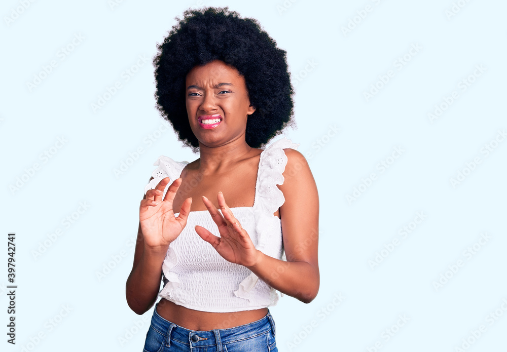 Young african american woman wearing casual clothes disgusted expression, displeased and fearful doing disgust face because aversion reaction. with hands raised Young african american woman wearing casual clothes disgusted expression, displeased and fearful doing disgust face because aversion reaction. with hands raised