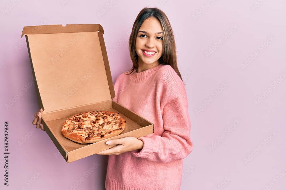Young brunette woman holding italian pizza smiling with a happy and cool smile on face. showing teeth.