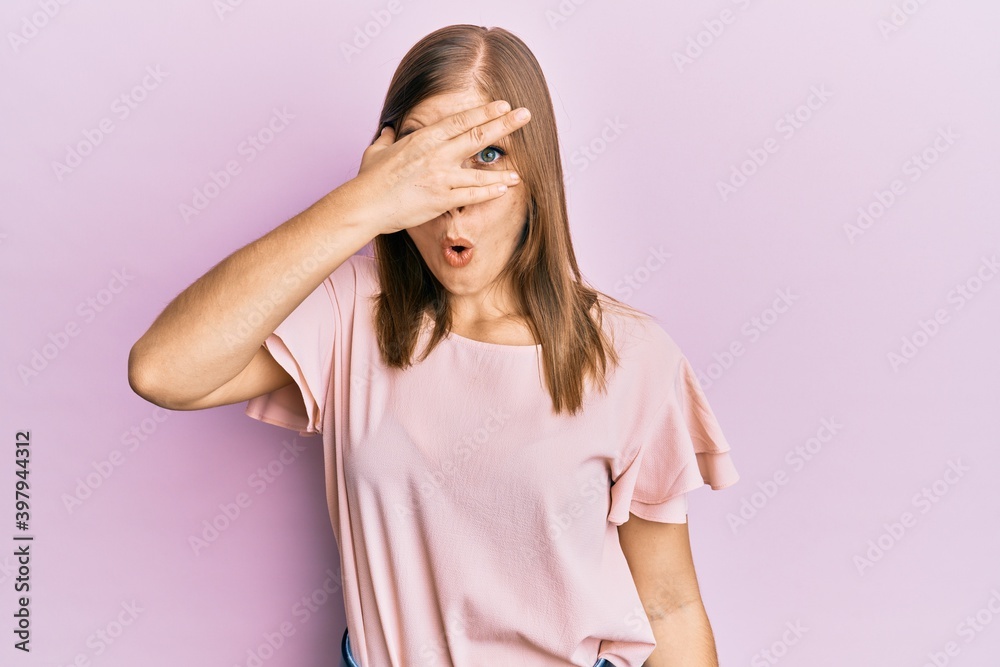 Beautiful caucasian woman wearing casual clothes peeking in shock covering face and eyes with hand, looking through fingers afraid Beautiful caucasian woman wearing casual clothes peeking in shock covering face and eyes with hand, looking through fingers afraid