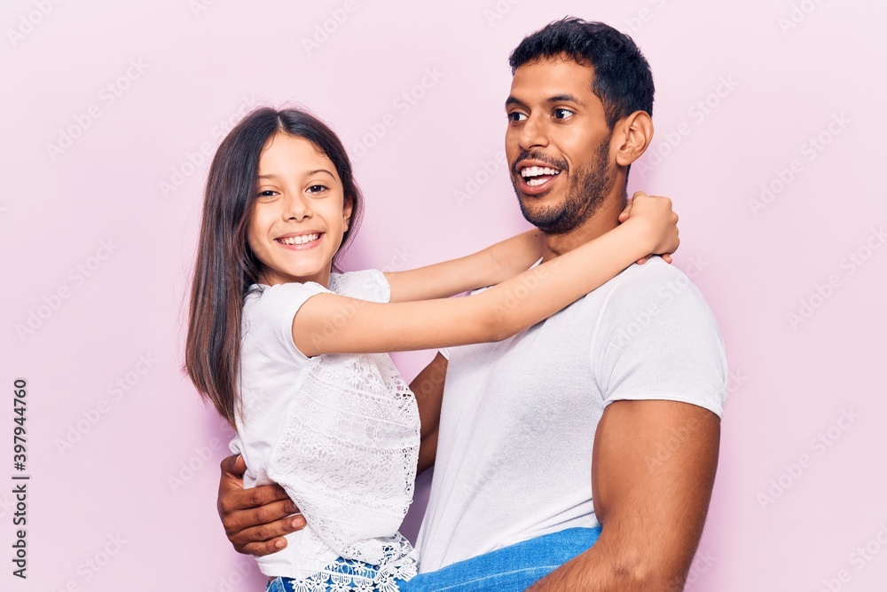 Hispanic young family of father and daughter hugging together with love Hispanic young family of father and daughter hugging together with love