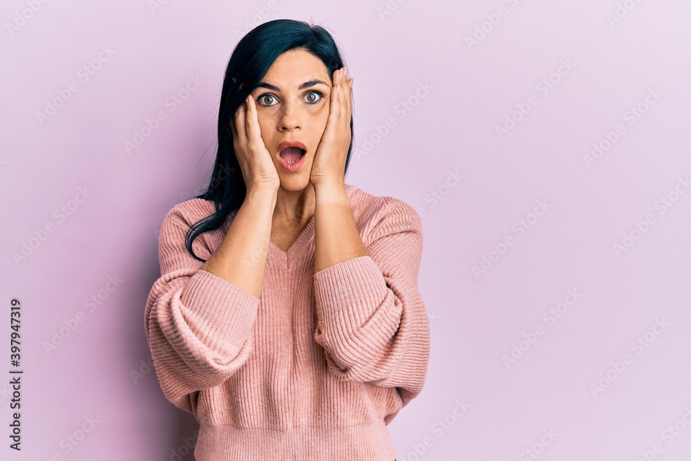 Young caucasian woman wearing casual clothes afraid and shocked, surprise and amazed expression with hands on face Young caucasian woman wearing casual clothes afraid and shocked, surprise and amazed expression with hands on face