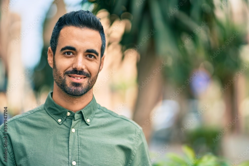 Fototapeta premium Young hispanic man smiling happy standing at the city.