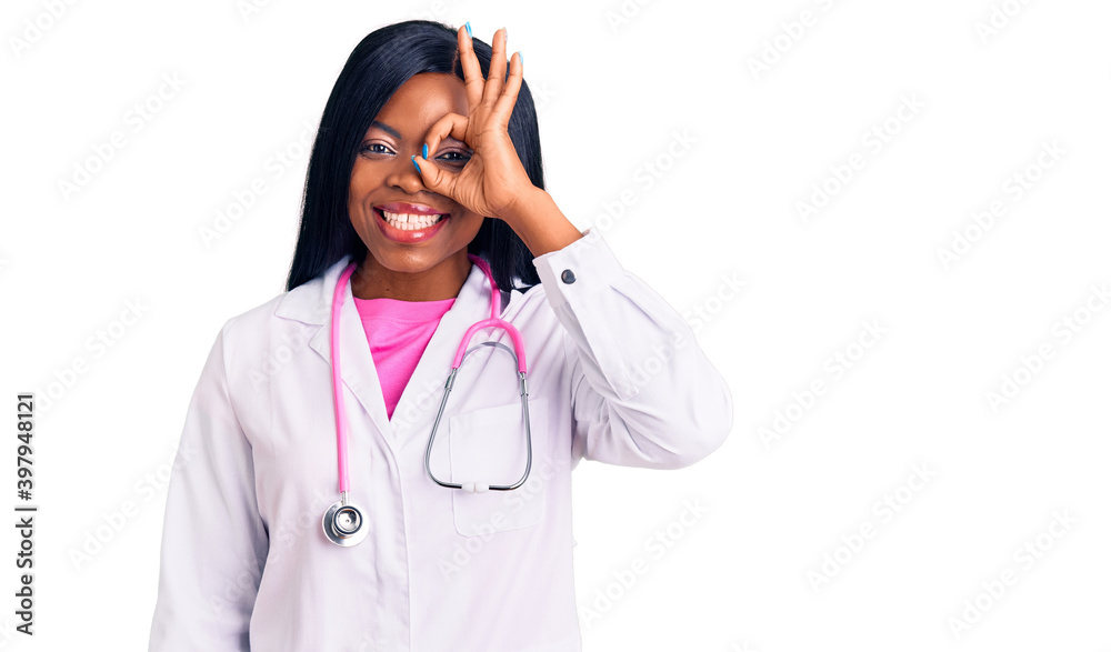 Young african american woman wearing doctor stethoscope doing ok gesture with hand smiling, eye looking through fingers with happy face. Young african american woman wearing doctor stethoscope doing ok gesture with hand smiling, eye looking through fingers with happy face.