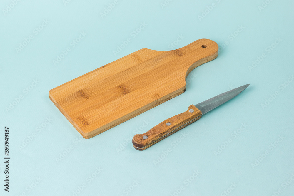 Wooden cutting Board and knife with wooden handle on blue background. Wooden cutting Board and knife with wooden handle on blue background.