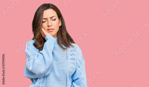 Young brunette woman wearing casual winter sweater touching mouth with hand with painful expression because of toothache or dental illness on teeth. dentist © Krakenimages.com