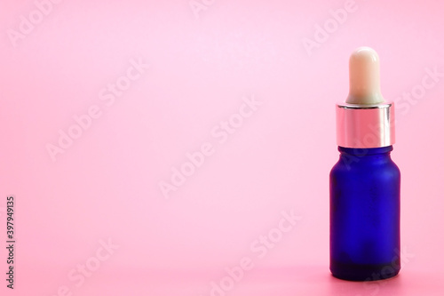 Serum bottle on pink color background.