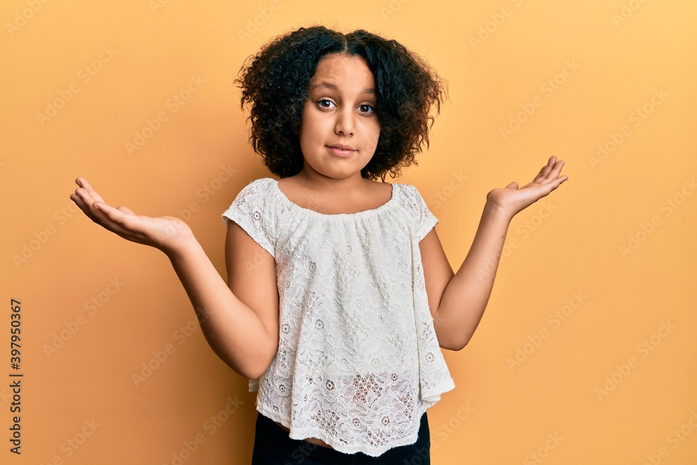 Young little girl with afro hair wearing casual clothes clueless and confused expression with arms and hands raised. doubt concept.