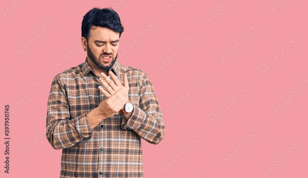 Young hispanic man wearing casual clothes suffering pain on hands and fingers, arthritis inflammation