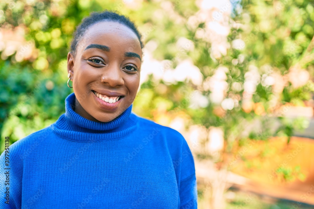 Young african american woman smiling happy walking at the park. Young african american woman smiling happy walking at the park.