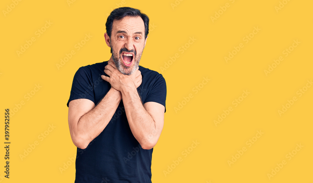 Middle age handsome man wearing casual t-shirt shouting and suffocate because painful strangle. health problem. asphyxiate and suicide concept. Middle age handsome man wearing casual t-shirt shouting and suffocate because painful strangle. health problem. asphyxiate and suicide concept.