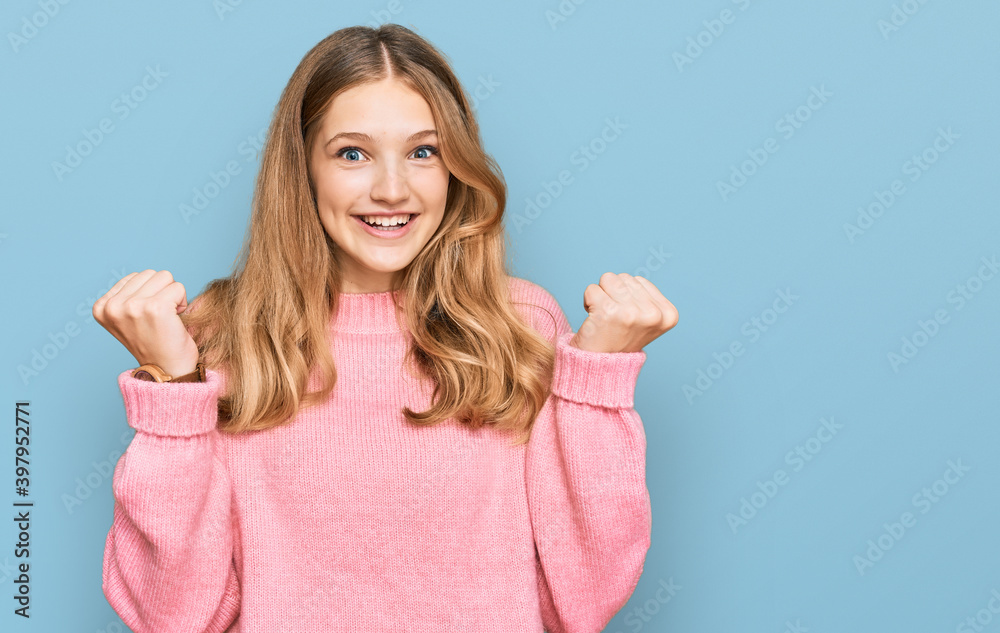 Fototapeta premium Beautiful young caucasian girl wearing casual winter sweater celebrating surprised and amazed for success with arms raised and open eyes. winner concept.